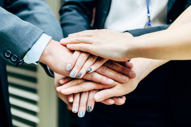 Business people with hands stacked on top of each other Male and female business colleagues making agreement, bonding, teamwork, collaboration, solidarity coalition stock pictures, royalty-free photos & images