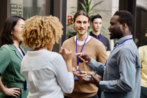 Business professionals having a casual chat after successful conference event stock photo