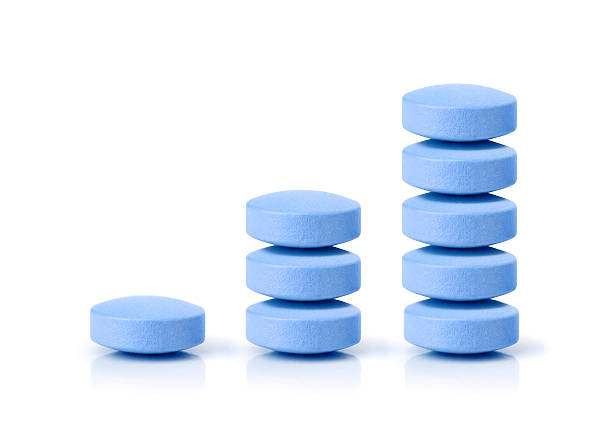 Business profit on pills Growth graph made of stacked blue pills on white background with reflection. Concept: growing pharmacy market and increasing demand for blue pill and it's substitutes. anti impotence tablet stock pictures, royalty-free photos & images