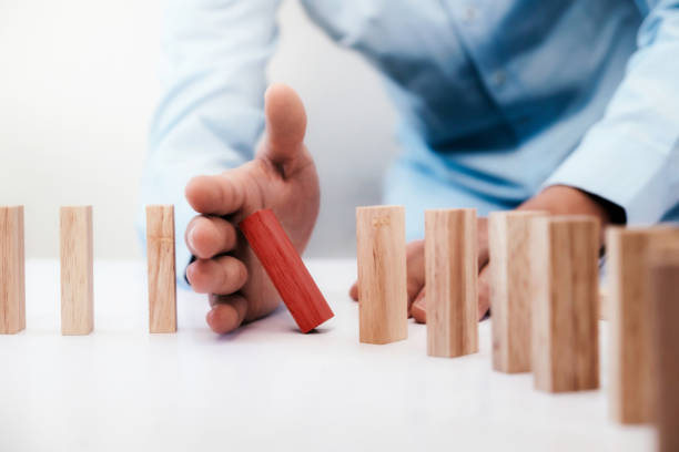 Business risk, strategy and planing concept idea. Businessman hand stop dominoes continuous toppled or risk with copyspace. Business risk, strategy and planing concept idea. execution stock pictures, royalty-free photos & images