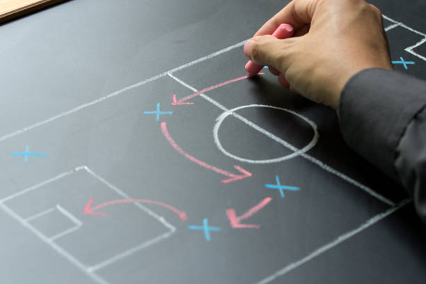 Business strategy concept Man planning for a football strategy on blackboard defending sport stock pictures, royalty-free photos & images