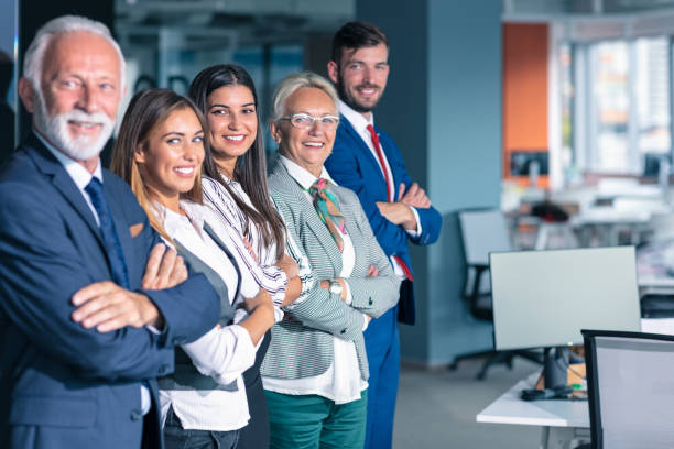 Business team in office, Happy Senior Businessman in His Office is standing in front of their team. stock photo