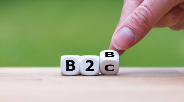 Business to Business or Busness to Consumer? Hand turns a dice and changes the expression "B2B" to "B2C" (or vice versa) stock photo