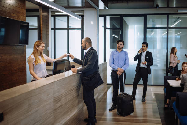 Business travelers checking in luxury hotel Business people in the corporate headquarters or hotel lobby hotel reception photos stock pictures, royalty-free photos & images