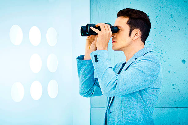 Business vision: man holding binoculars stock photo