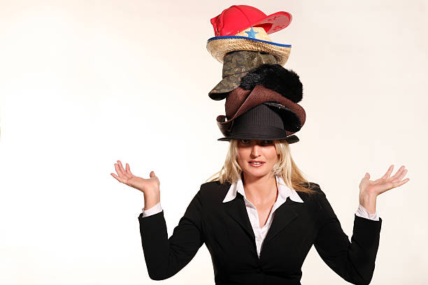 business woman balancing life having to wear too many hats - hoed stockfoto's en -beelden