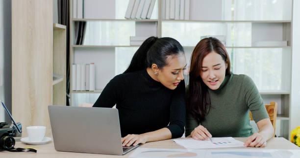 Business woman consulting with colleagues Plan information from the laptop in the office. working with teamwork. Business client consultation stock photo