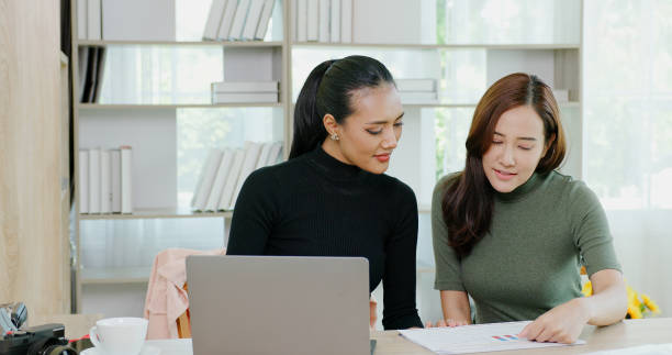 Business woman consulting with colleagues Plan information from the laptop in the office. working with teamwork. Business client consultation stock photo
