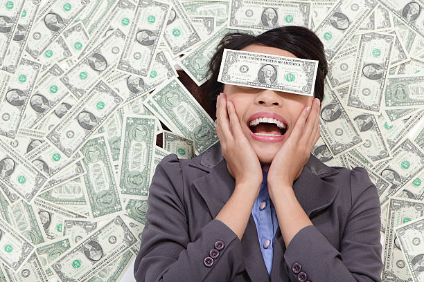Young business woman excited lying on money background and money...
