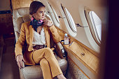 istock Business woman looking from window in airplane 1329895293