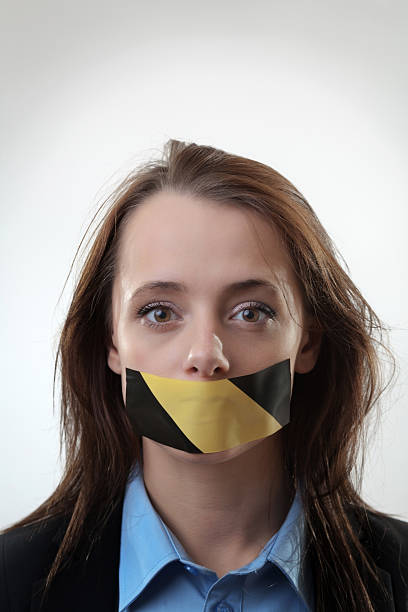 business woman A picture of a young woman with a tape on her mouth human mouth gag adhesive tape women stock pictures, royalty-free photos & images