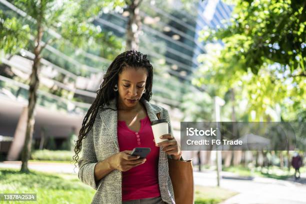 Business woman using smartphone outdoors
