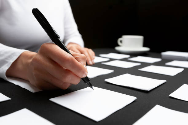 Business woman writes a note on a paper sheet post planning the development of the project. stock photo