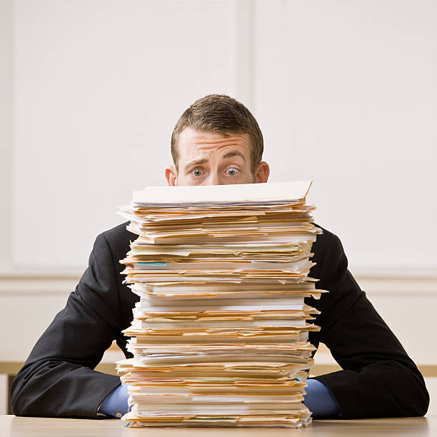 Businessman Behind Stack of File Folders stock photo