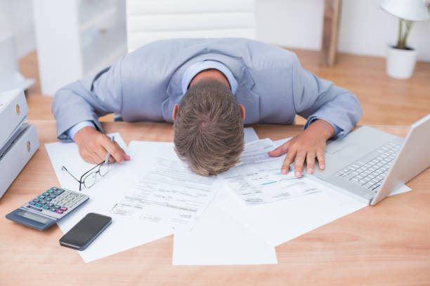 Businessman being depressed by accounting Businessman being depressed by accounting in his office banging your head against a wall stock pictures, royalty-free photos & images