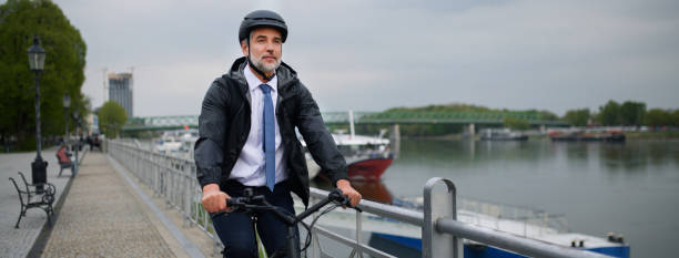 Businessman commuter on the way to work, riding bike in city, sustainable lifestyle concept. stock photo
