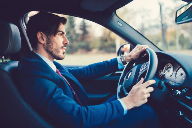 Businessman driving a car Young man traveling to work with car man driving suit stock pictures, royalty-free photos & images