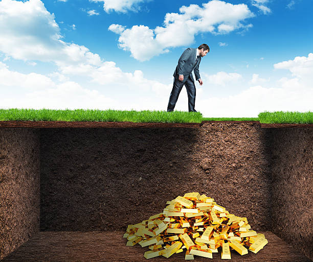 Businessman found treasure in the soil Businessman bends and looks at the treasure in the soil buried stock pictures, royalty-free photos & images