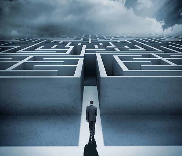 Businessman getting in a maze Businessman getting in a maze with dark cloudy sky on the background maze photos stock pictures, royalty-free photos & images