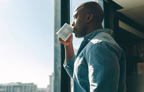 zakenman die koffie in modern bureau heeft - africa cup stockfoto's en -beelden