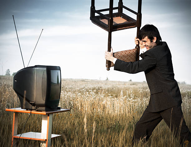 Businessman hitting the TV stock photo