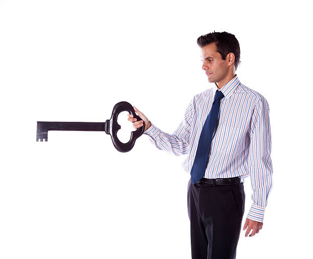 Businessman holding a giant key stock photo