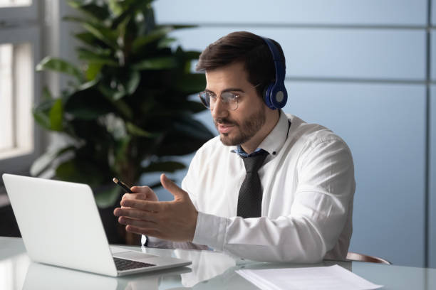 businessman in headphones makes videocall chatting with partner consulting client - businessman train working imagens e fotografias de stock