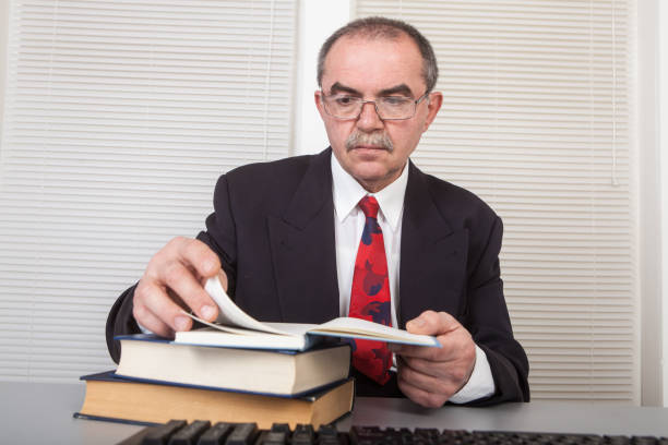 Businessman in office with books stock photo