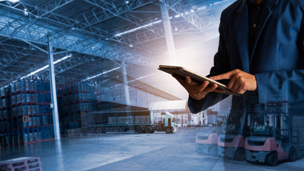 Businessman manager using tablet check and control for workers with Modern Trade warehouse logistics. Industry 4.0 concept,planning of logistics, Transportation within the country and Global. stock photo