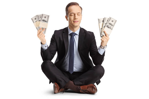 Businessman meditating and holding money stock photo