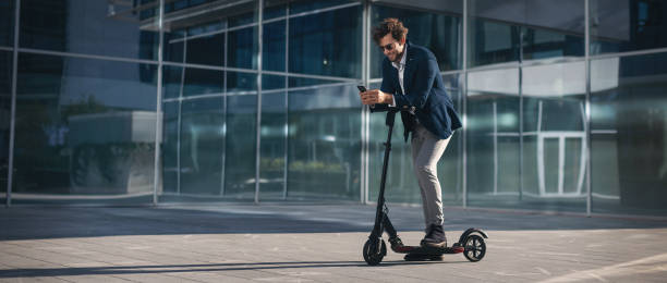 Businessman on e scooter in the city stock photo