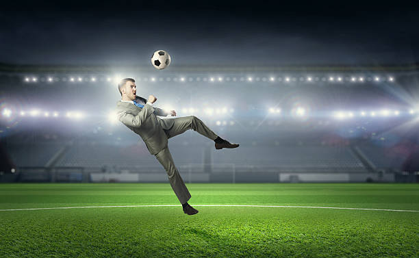Businessman playing soccer . Mixed media stock photo