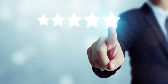 Businessman pointing five star symbol to increase rating of company