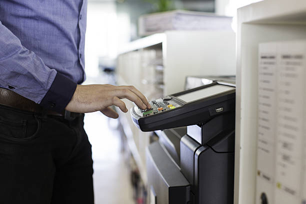 Businessman pressing the start button to print. stock photo