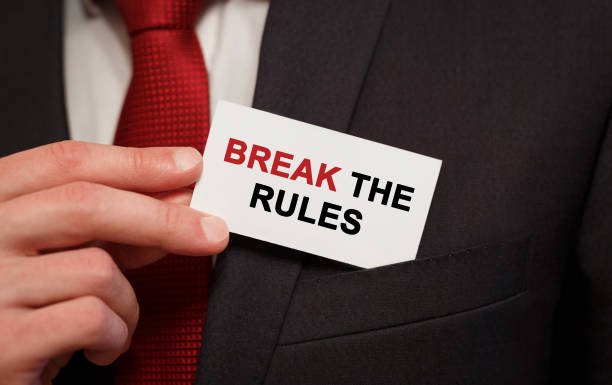Businessman putting a card with text Break the Rules in the pocket Businessman putting a card with text Break the Rules in the pocket rule breaker stock pictures, royalty-free photos & images