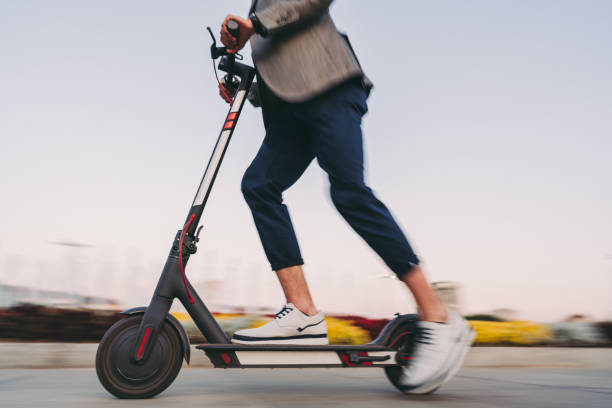 zakenman rijdt op een scooter in sofia - elektrische step stockfoto's en -beelden