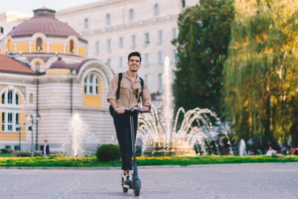 Businessman riding a scooter in the city stock photo