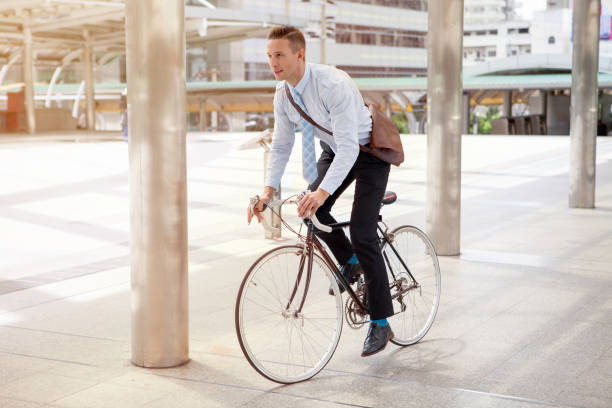 Businessman riding bicycle to work on urban street in morning .transport and healthy stock photo