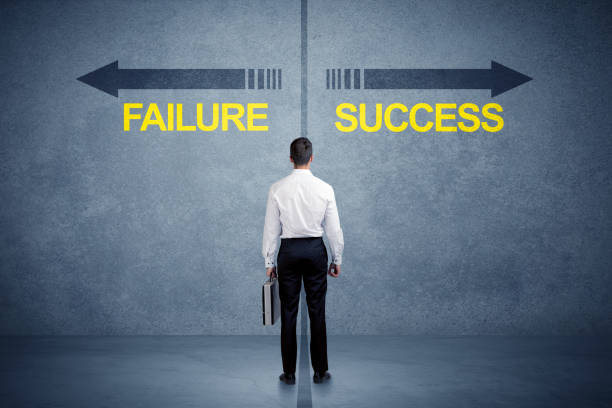 Businessman standing in front of success and failure arrow concept stock photo