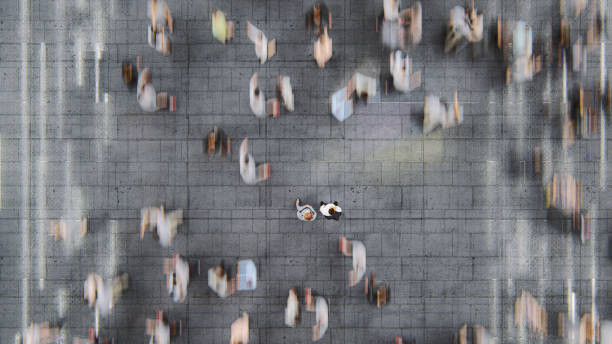 通勤者の動きの速い群衆の中に立つビジネスマン - 街　俯瞰 ストックフォトと画像