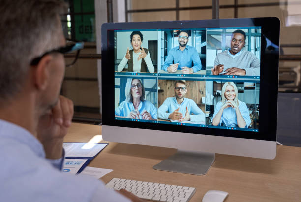 Businessman talking with team leading virtual meeting on computer. Over shoulder stock photo