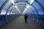 business commuter on urban elevated walkway at dusk, London, UK,