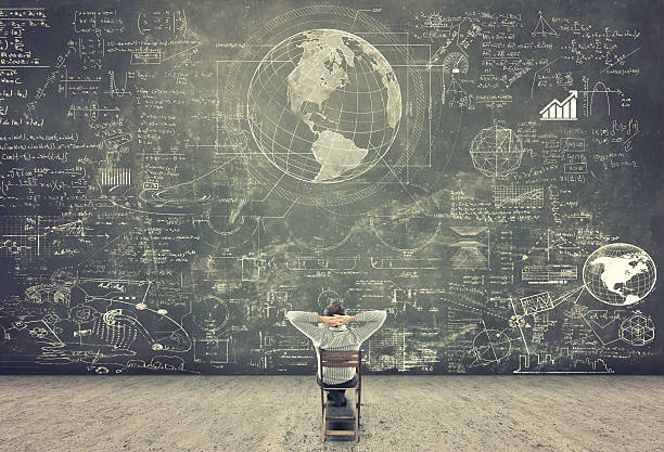 Businessman watching formulas Businessman sitting on a chair and studying math formulas on blackboard chalkboard visual aid stock pictures, royalty-free photos & images