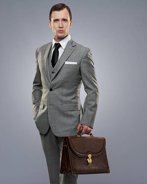 Businessman with a briefcase isolated on grey. stock photo