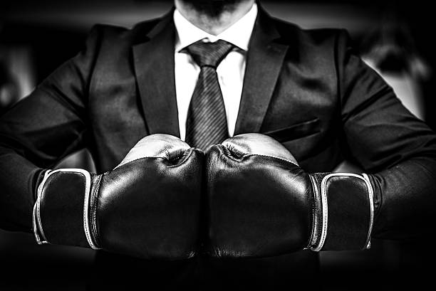 Businessman with boxing gloves is ready for corporate battle. stock photo