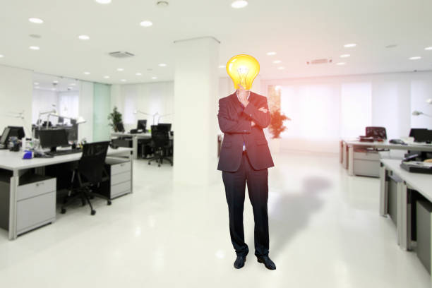 Businessman with bulb instead his head standing in the office stock photo