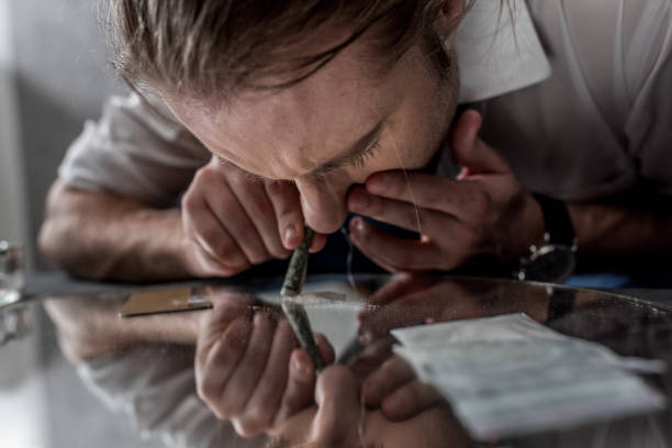 businessman with drug addiction sniffing cocaine from mirror businessman with drug addiction sniffing cocaine from mirror snorting stock pictures, royalty-free photos & images