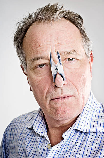 businessman-with-peg-on-his-nose-picture-id154947418