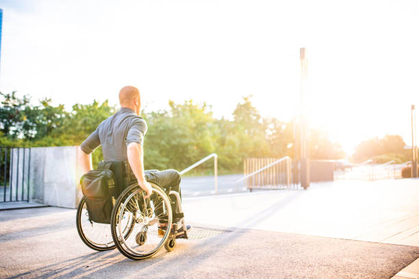 Businessman with Physical Disability Rolling into Sunshine stock photo