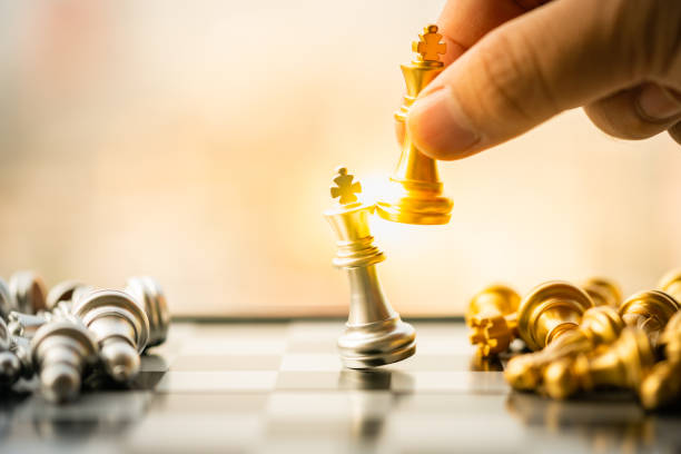 Businessman's hand moving chess figure in competition success play. stock photo